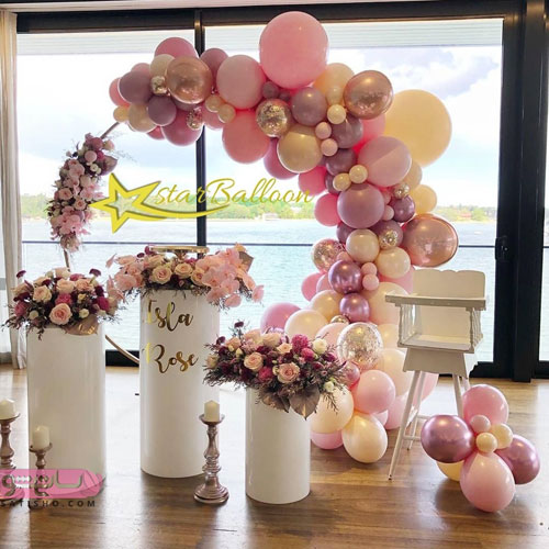 دیزاین اتاق تولد با بادکنک هلیومی متالیک در کنار دسته های گل طبیعی 